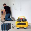 Blue EVA core anti vibration pads placed under the feet of a portable air compressor in a workshop
