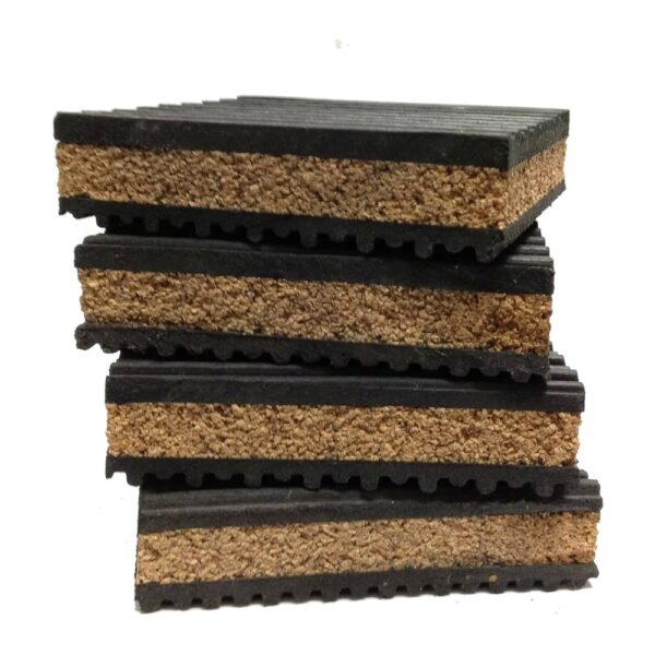 cork-rubber-anti-vibration-pad-layer-detail Cork rubber anti vibration pads stacked front on, with the cork core and the toothed rubber facings visible on the cut edge