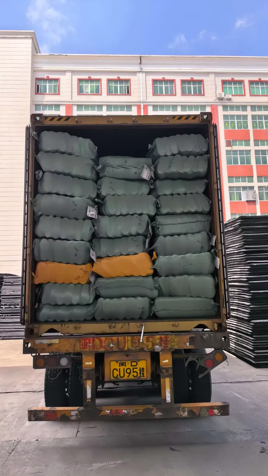 Shipping container loaded with bags of EVA hotel slipper soles at the SANSD plant in Jinjiang