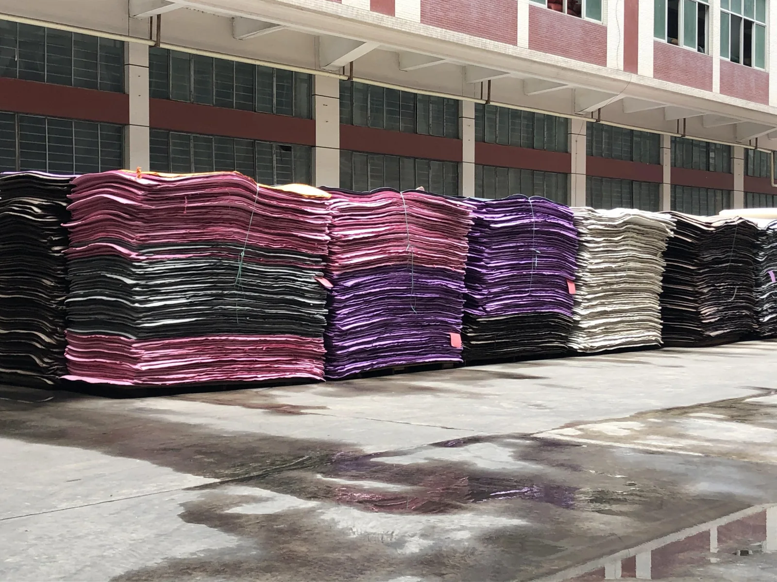 Stacks of coloured EVA foam sheets in black, pink, purple and grey outside the SANSD factory in Jinjiang