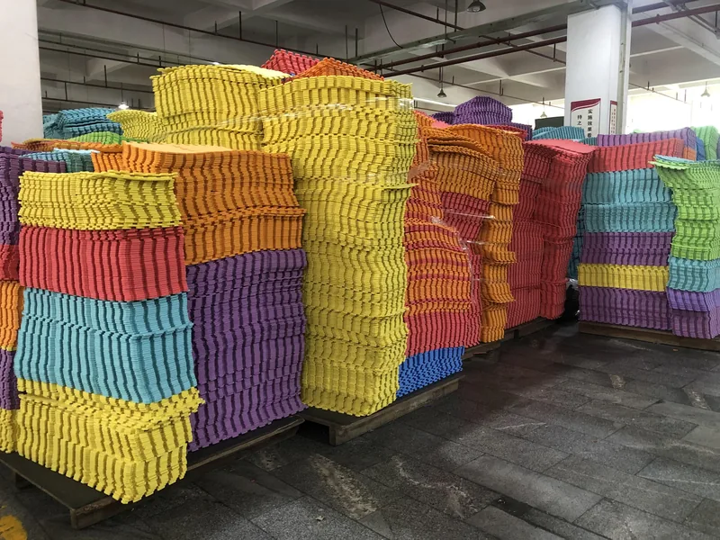 Pallets of colourful interlocking EVA foam puzzle mat tiles stacked in the SANSD warehouse