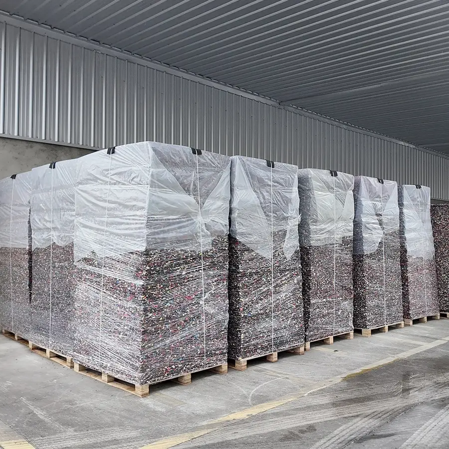 Pallets of rebonded EVA shock pad sheets wrapped in stretch film under a loading canopy